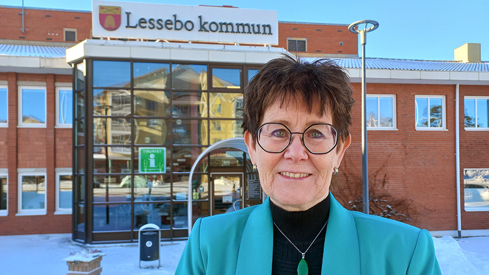 Ett foto på kommunchef Christina Nyquist som står framför kommunhuset i Lessebo.