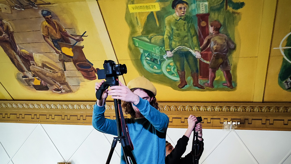Två personer fotograferar takmålningarna i Kulturhuset i Lessebo.